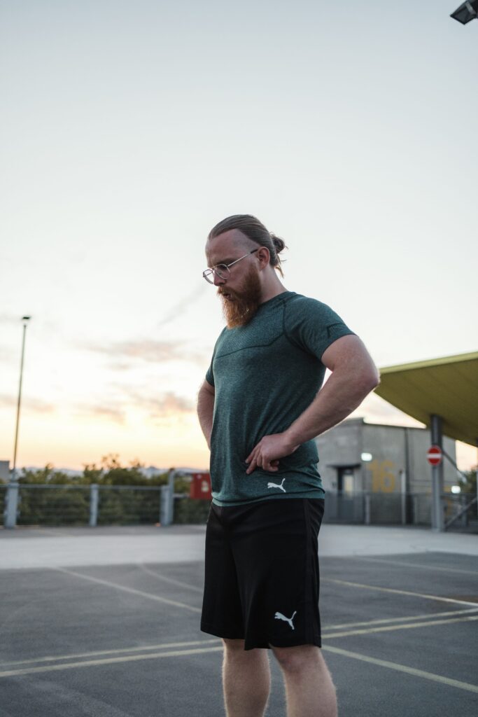 Personal Trainer Matthäus steht auf dem Parkdeck in Frankfurt und macht Pause zwischen zwei Sätzen