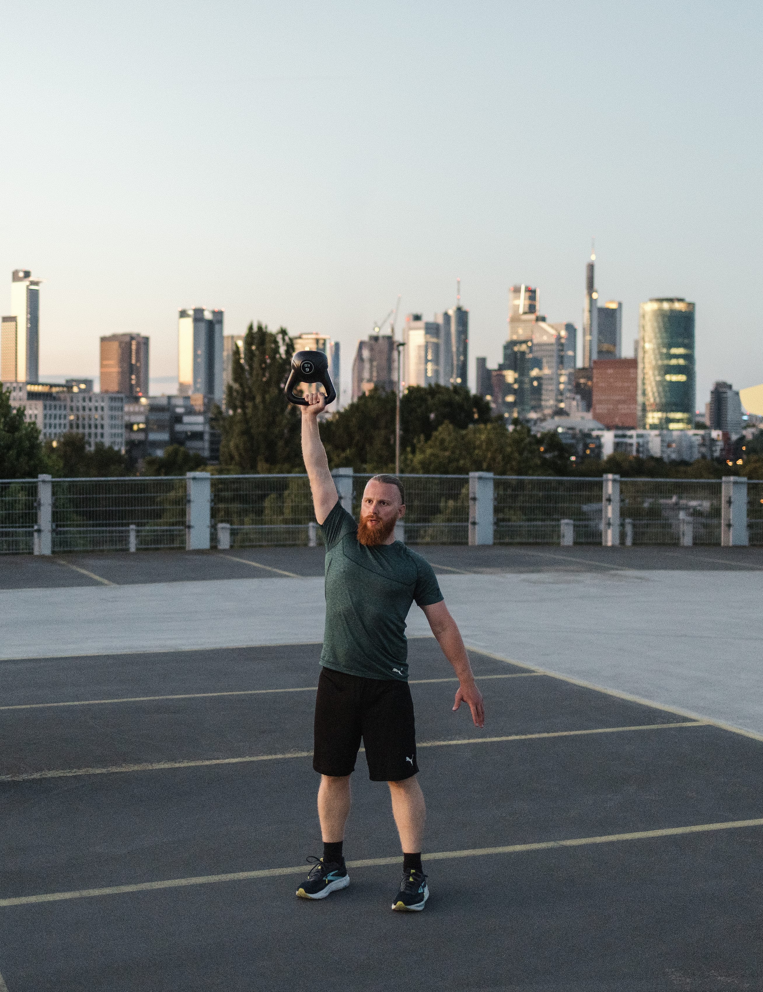 Kettlebell über Kopf gestreckt vor der Frankfurter Skyline