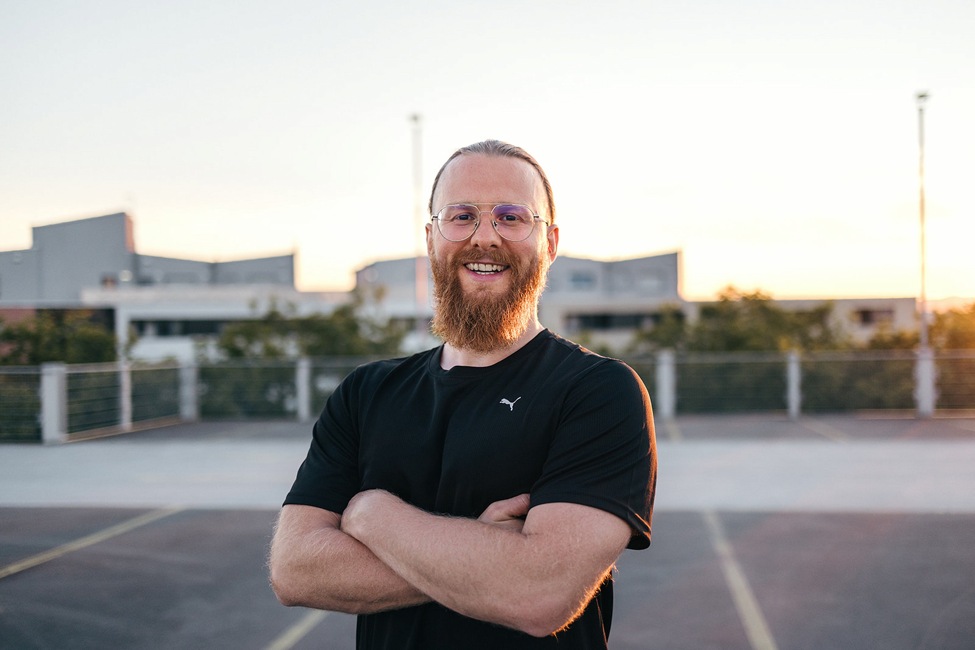 Personal Trainer Matthäus lächelt mit verschränkten Armen in die Kamera