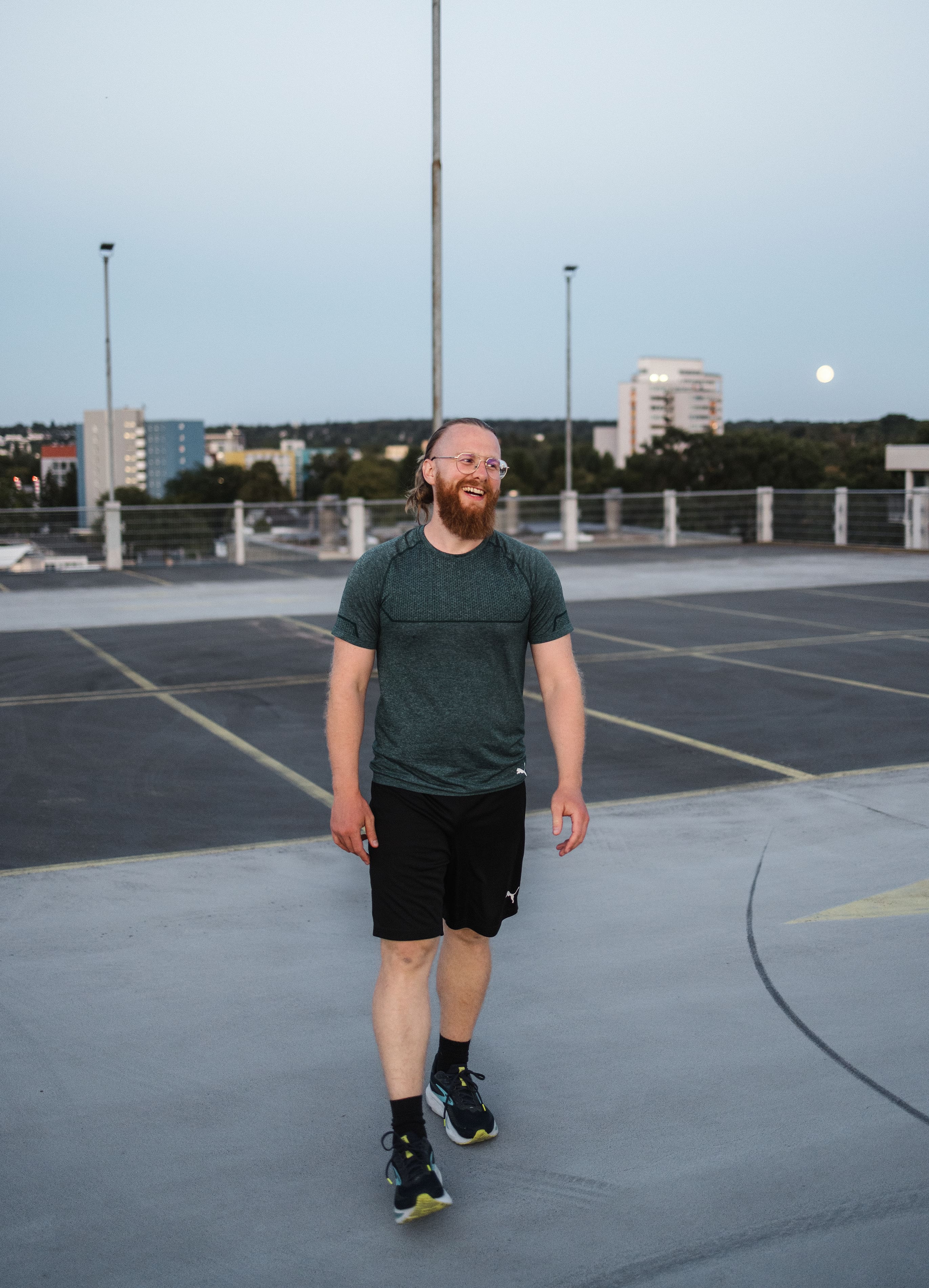 Personal Trainer Matthäus geht über das Parkdeck auf die Kamera zu